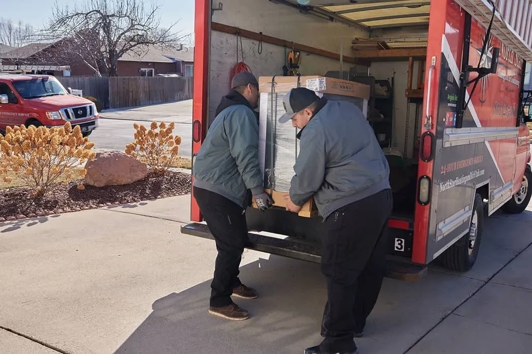 North Star HVAC technicians unloading a new AC unit at a Utah home
