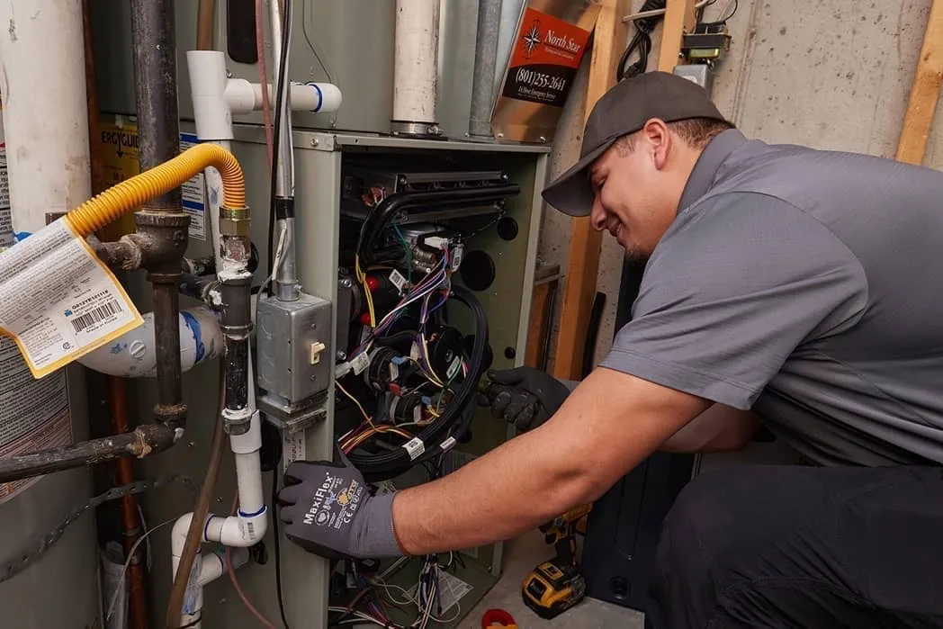 Technician performing maintenance on heat pump wiring