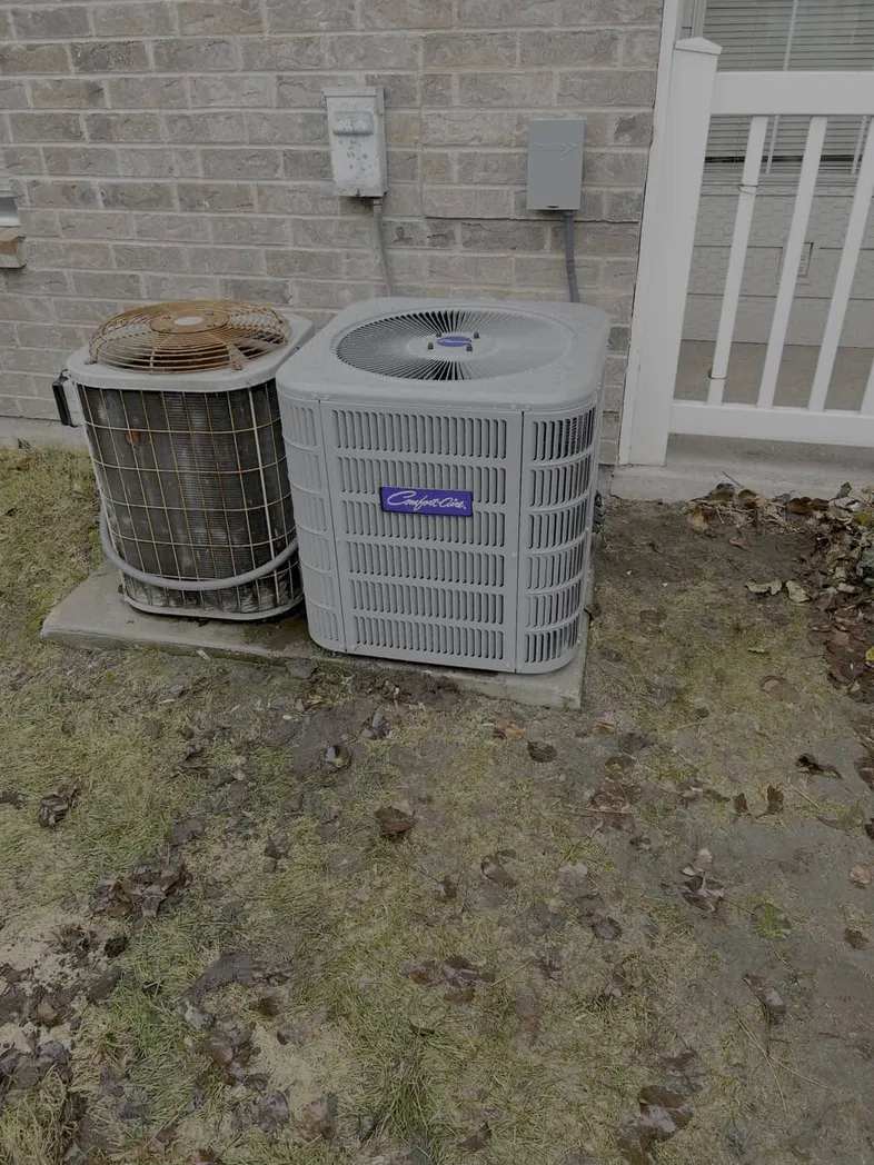 Outdoor heat pump units installed against a brick wall